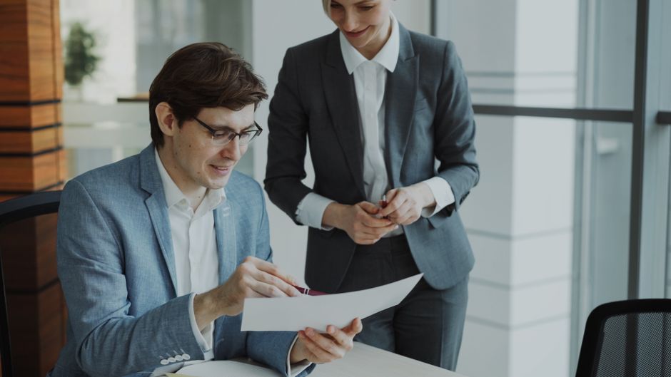 Business professionals discussing financing documents in a modern office