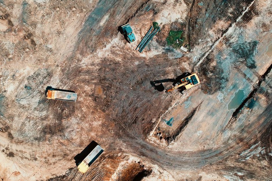 Aerial view of a construction site with earthmoving equipment and trucks