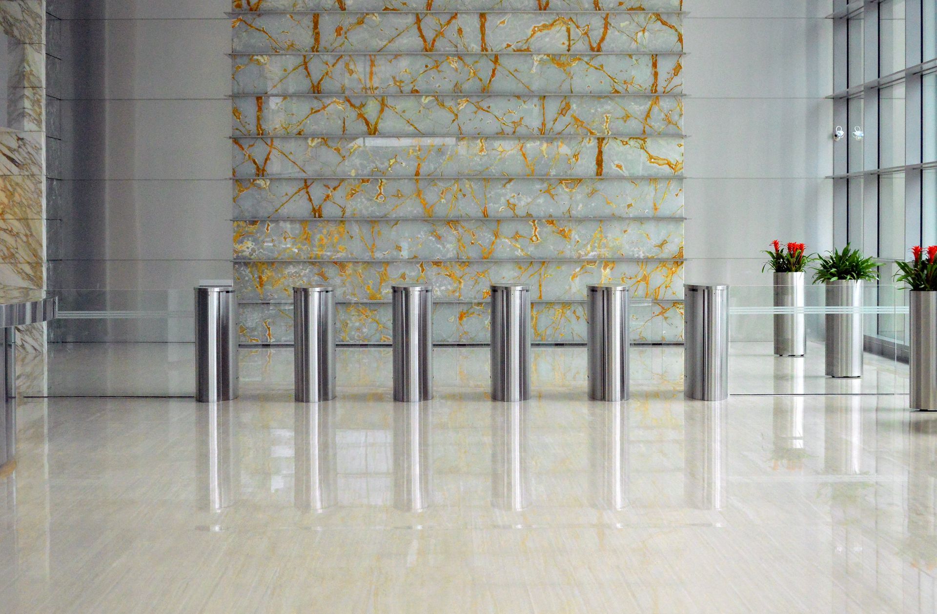 A sleek corporate lobby featuring marble walls, metal dividers, and glass windows for a sophisticated design