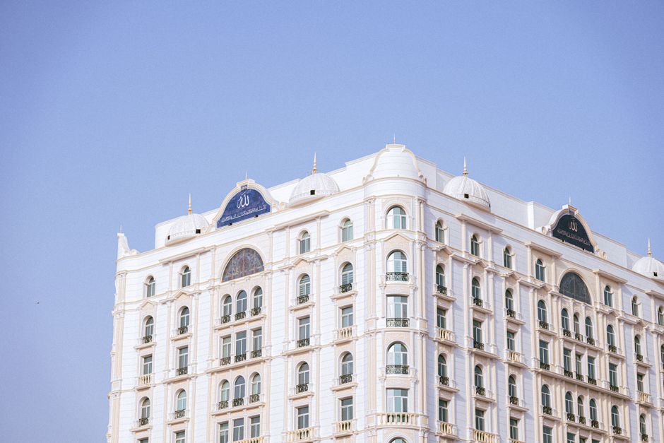 Luxurious white hotel facade with classic architecture under a clear blue sky