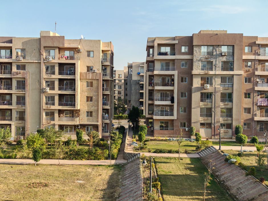 Aerial view of modern apartment buildings with a landscaped courtyard, showcasing urban living