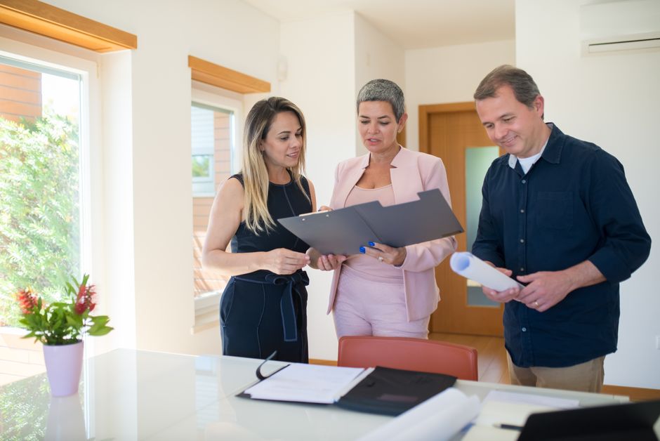 Real estate professionals examining documents in a modern office setting